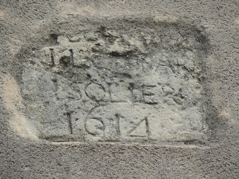 Dans un mur, une pierre préservée datant de 1614.